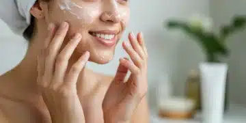 Mulher com pele radiante realizando limpeza facial dupla, aplicando o primeiro passo da rotina de skincare.