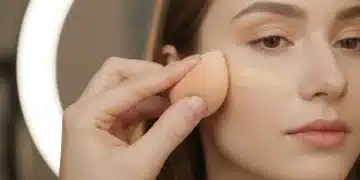 Makeup artist blending foundation on a model's face for a professional finish.